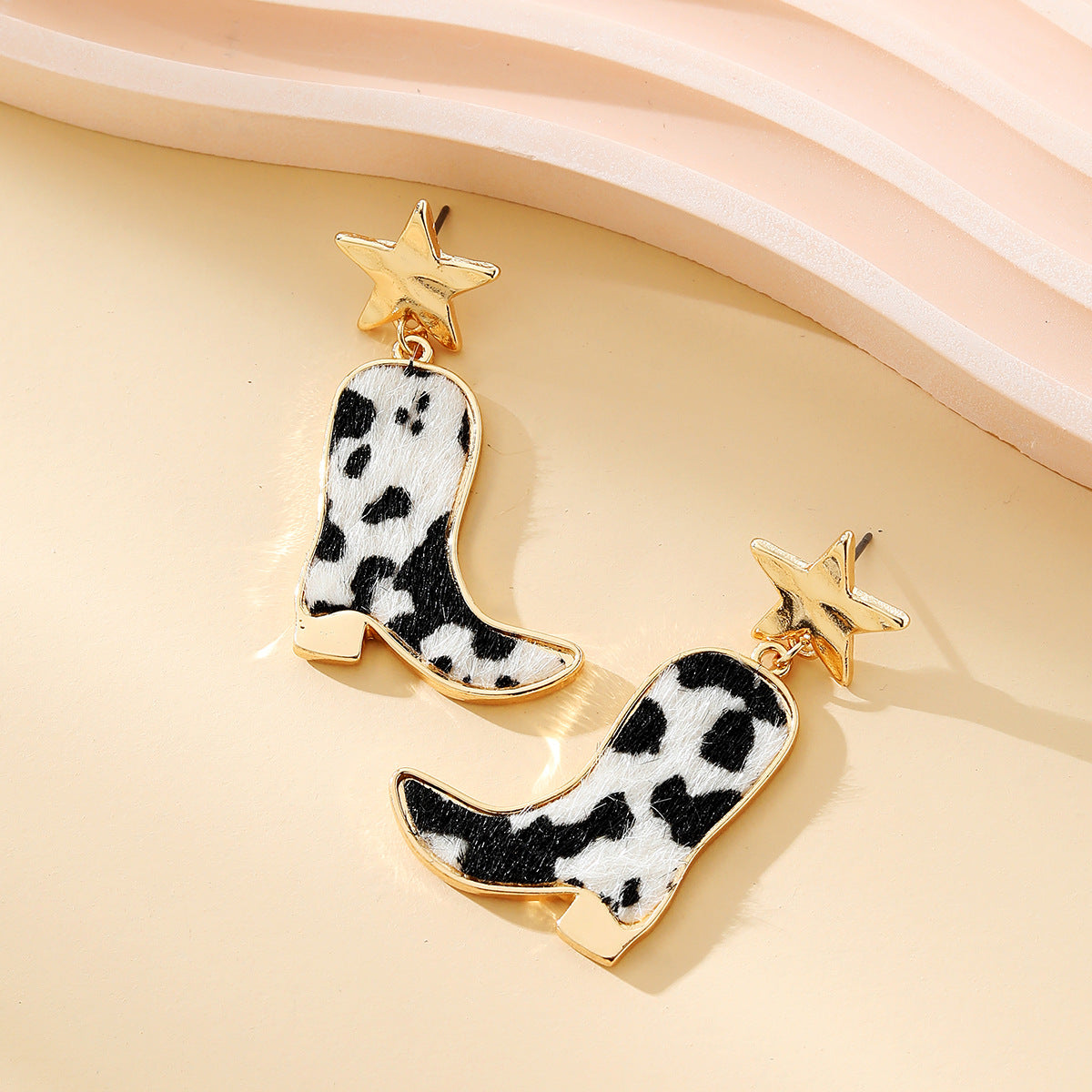 Western style cow patterned boots and star earrings